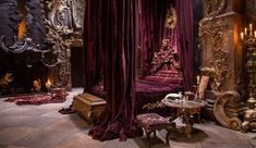 an elaborately decorated bedroom with purple drapes