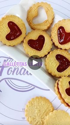 some heart shaped cookies on a plate with jam in the middle and another cookie next to it