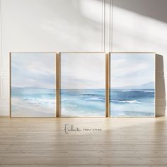 three paintings on the wall in an empty room with wood flooring and white walls