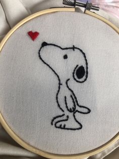 there is a embroidered picture of a dog with a red heart on it's back