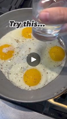 someone is frying three eggs in a pan on top of the stove with water