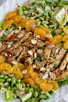 a white plate topped with salad covered in oranges and nuts