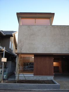 a modern house with wooden doors and windows on the outside, in front of an empty street