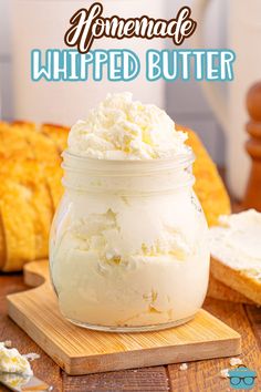 homemade whipped butter in a mason jar on a wooden cutting board with bread behind it