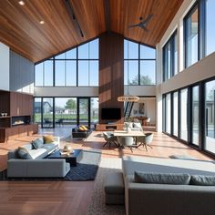 a large open living room with high ceilings and wood flooring on the walls, along with modern furniture