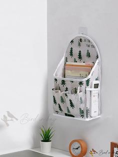 a white wall hanging organizer with trees on it