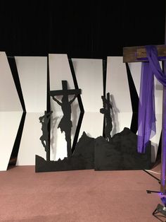 there is a crucifix in the middle of this stage with purple drapes