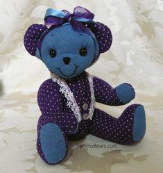 a blue teddy bear sitting on top of a bed