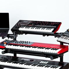 a laptop computer sitting on top of an electronic keyboard next to other musical instruments and keyboards