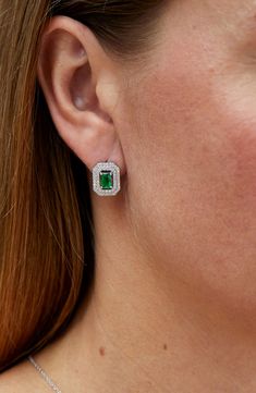 Concentric rings of sparkling cubic zirconia frame the lab-created emeralds of these elegant stud earrings. 3/8"W x 1/2"L   Sterling silver/cubic zirconia/lab-created emerald   Imported Emerald Cut Cubic Zirconia Halo Jewelry, Emerald Cut Earrings With Halo Setting For Anniversary, Emerald Cut Halo Setting Earrings For Anniversary, Emerald Cut Cubic Zirconia Earrings With Diamond Accents, Diamond Halo Setting Earrings For May Birthstone, Diamond Halo Earrings For May Birthstone, Formal Jewelry With Pave Setting For May Birthstone, Emerald Cut Cubic Zirconia Earrings In Fine Jewelry Style, Cubic Zirconia Jewelry With Halo Setting For May Birthstone