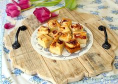 small pieces of food on a plate with flowers in the background