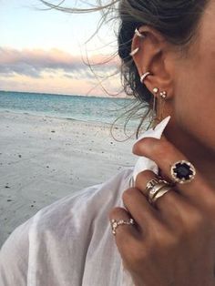 a woman wearing ear rings on the beach