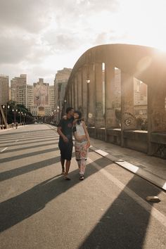 two women walking down the street in front of a bridge