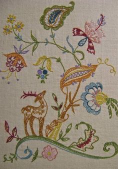 an embroidered design with flowers and birds on it's side, in white linen