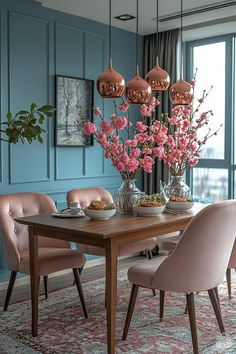 a dining room with blue walls and pink chairs