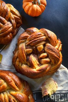 some very tasty looking pastries sitting on a towel with pumpkins in the background