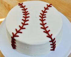 a white cake with red stitches on it that has a baseball ball in the middle