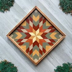 a wooden box with an intricate design on the inside and sides, surrounded by pine needles