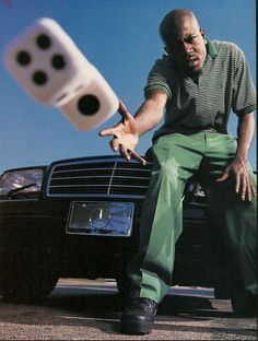 a man sitting on the hood of a car with two dices in front of him