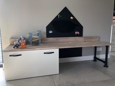 a desk with drawers and toys on it in a room that has been painted white