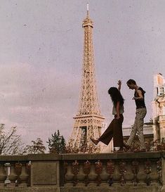 two people standing in front of the eiffel tower