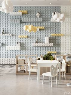 a white table and chairs in a room with legos on the wall behind it