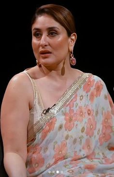 a woman in a floral sari sitting down