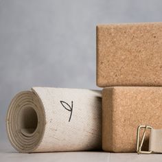 two rolls of yoga mat next to each other on top of the floor with one roll tied up