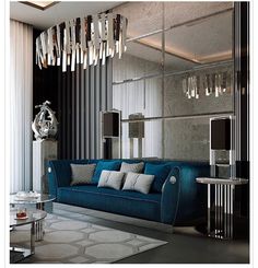 a modern living room with blue couches and chandelier hanging from the ceiling