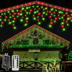 christmas lights decorate the roof of a house in front of a clock tower and reindeer figures