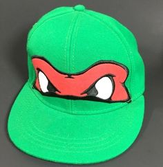 a green baseball cap with red eyes on it