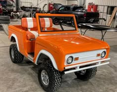 an orange and white truck parked in a garage