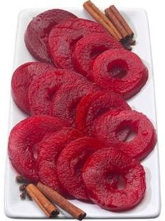 sliced beets on a white plate with cinnamon sticks