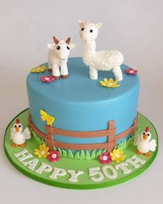 a birthday cake decorated with two farm animals on top of the cake is blue and green