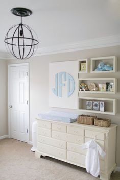 a baby's room with a dresser, crib and bookcases on the wall