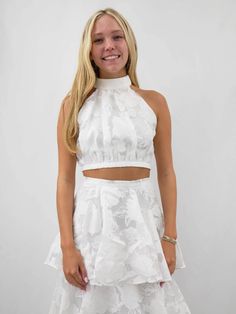 Elevate your formal wardrobe with this exquisite white layered two piece set, perfect for bridal occasions and elegant events. Featuring a sophisticated high halter neck with a zipper closure at the back, this set is crafted from a delicate, floral-patterned fabric that exudes romance and grace. The fitted bodice reveals a subtle midriff before flowing into a voluminous, tiered skirt with cascading ruffled layers that create a dreamy, ethereal silhouette. Each tier is intricately detailed, showc Black Date Night Outfit, White Two Piece Set, White Two Piece, Black Dating, Nashville Style, Denim Jacket With Dress, Bride Accessories, Playsuit Romper, Summer Knitting