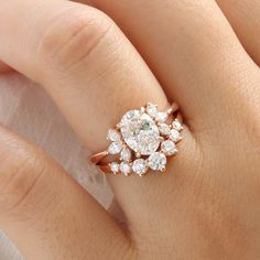 a woman's hand with a rose shaped diamond ring on top of her finger