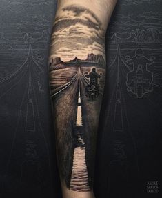 a man's leg with a black and grey tattoo on it