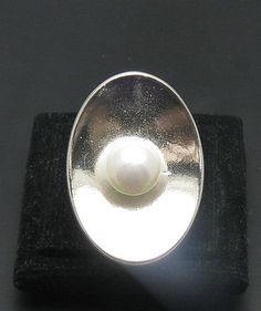 Sterling silver ring 925/1000. Ellipse with 8mm round synthetic pearl. Adjustable size.Stamped 925.Approximate weight 11.5 grams. Front dimensions 2.9x2.0cm. All our jewels are made from solid sterling silver 925/1000 and are carefully crafted by hand in our family workshop. We dispatch your orders in 5 working days, worldwide and the postage is $5. We ship registered priority mail. Please allow 5-7 working days for delivery in Europe and 10-15 working days outside Europe. For any questions - pl Modern Silver Pearl Ring, Formal Oval Silver Pearl Ring, Formal Silver Oval Pearl Ring, Formal Round Pearl Ring Stamped 925, Ring With Pearl, Sterling Silver Ring, Priority Mail, Bulgaria, Silver 925