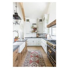 a kitchen with white cabinets and an area rug