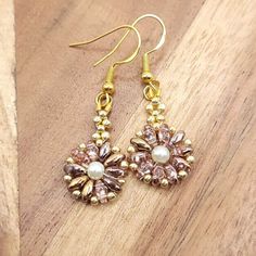 These blushed pink and gold earrings are very light weight, half an inch wide with a little over an inch drop. The flower shaped earrings are made of blushed pink and gold glass twin beads, gold glass seed beads, with a pearl center. The earring wires are hook style. Hooks are gold, nickel-free and hypo-allergenic. Earring backs are made of clear silicone. Perfect for any fall gathering, holiday party, or paired with some cute jeans or leggings!  Please feel free to message me if you have any qu Gold Flower Beaded Earrings As Gift, Handmade Gold Flower Earrings With Round Beads, Handmade Dainty Gold Crystal Earrings, Gold Round Beads Flower Earrings As Gift, Gold Flower Earrings With Round Beads For Gift, Gold Beaded Flower Earrings With Ear Wire, Gold Beaded Flower Earrings For Party, Gold Flower-shaped Beaded Earrings With Ear Wire, Pink Gold Drop Earrings