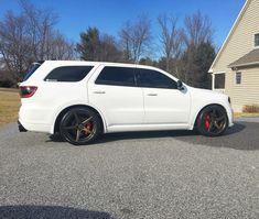 a white suv parked in front of a house