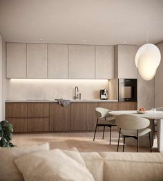 a living room and kitchen area in a house with wood flooring, white walls and beige furniture