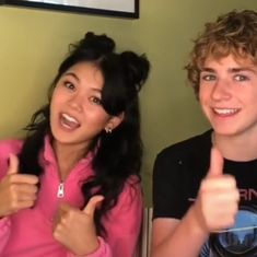 two young people giving the thumbs up sign