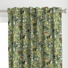 a green curtain hanging on the side of a window with birds and flowers all over it