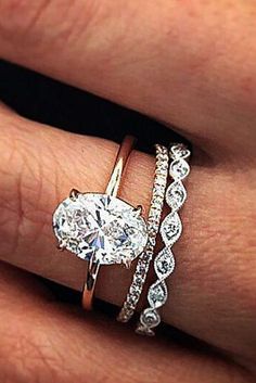 a woman's hand with three different rings on her finger and one diamond ring