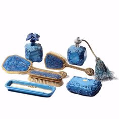 an assortment of blue and gold bathroom accessories on a white background with clippings