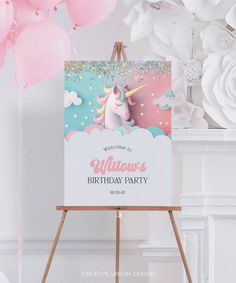 a unicorn birthday party sign with pink and blue balloons in the background, on an easel