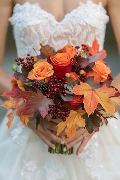 a bride holding a bouquet of flowers and leaves