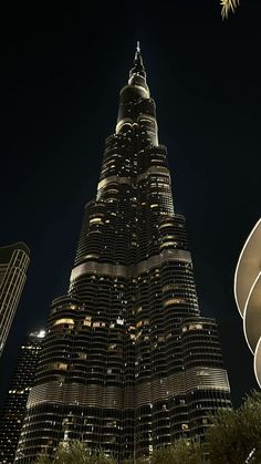 the burj building is lit up at night with stars in the sky above it